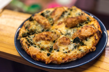 Pizza served on wooden circle board