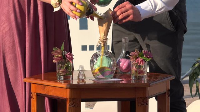 Wedding Sand Ceremony. Guests are pouring the colored sand into the vase.  Kotor bay, Montenegro.