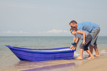 Father and son  playing on the beach at the day time.