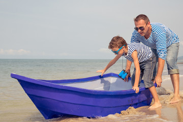 Obraz premium Father and son playing on the beach at the day time.
