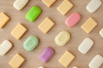 Solid soap on a wooden background. View from above. Many multi-colored solid soaps for hygiene and cleanliness.