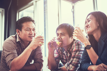 businessteam relaxing and talking in nightclub ; businessman drinking beverage in counter at nightclub