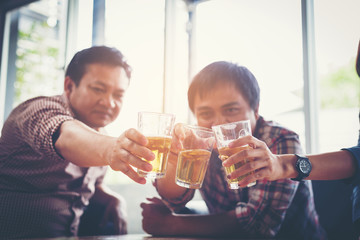 businessteam relaxing and talking in nightclub ; businessman drinking beverage in counter at nightclub
