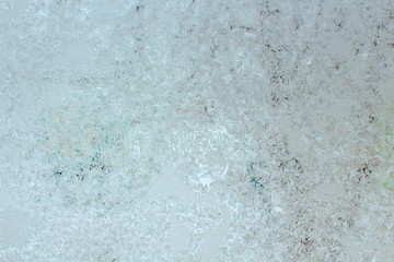 Winter patterns on the glass. The frozen glass in the winter. Close-up. Background. Texture.
