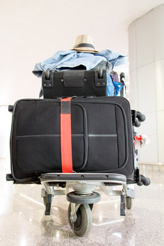 A pile of luggage on a cart at the airport. Suitcase loaded on the trolley, stand in the hall.