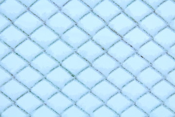 The fence of the grid is covered with snow. Close-up. Background. Texture.