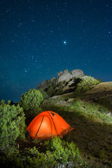 Illuminated camping travel tent in a mountains