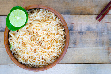 Instant noodles in wooden cup on wood background, Top view,Thai food style,  junk food concept.