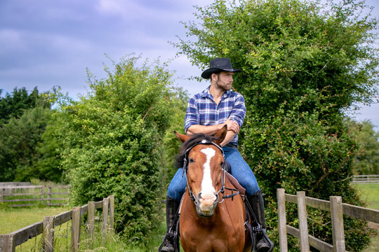 Handsome cowboy, horse rider on saddle, horseback and boots