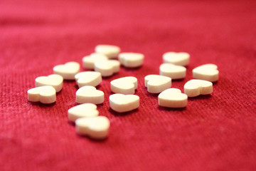 Heart pills in the form of hearts. Close-up. Background. Texture.