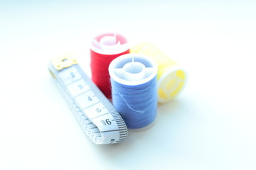Colored thread and a tailor's meter. Close-up. Isolated.