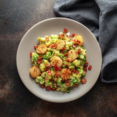 Fried scallops with mash potato, green peas and bacon