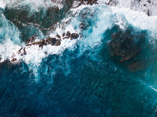 Aerial view of Hawaiian coast with waves splashing against rocks