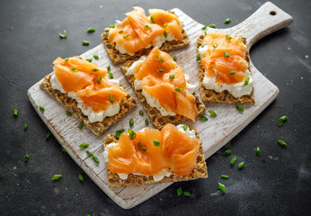 Homemade Crispbread toast with Smoked Salmon and soft chees, chives on white board