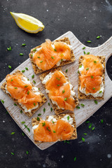 Homemade Crispbread toast with Smoked Salmon and soft chees, chives on white board