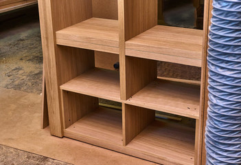 Fototapeta na wymiar Joinery. Oak veneered mdf wardrobe in workshop. Wooden furniture. Details wood production