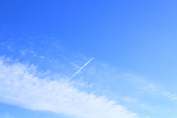 The blue sky and white clouds and the flying high passenger plane. Landscape. Background. Texture.