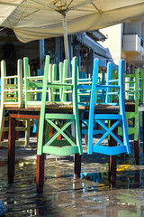 Fototapeta na wymiar Colorful chairs stacked on a table in the old port of Chania