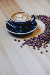 cup of delicious coffee with coffee beans