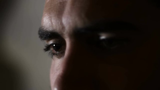 Depressed sad man's eyes in the dark- close up