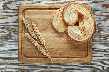 Carving board rolls wheat ears on vintage wooden surface