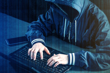 Anonymous hacker uses a laptop to hack the system. Stealing personal data and infection of...