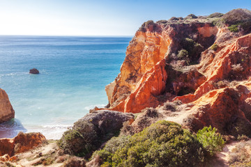 Red rocks and blue sea on the Atlantic coast in Portugal, Algarve region, beautiful stunning bright...
