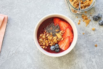 
    Smoothie. Berrie smothie with granola, chia seeds, strawberry and blueberry topping. Super food, clean eating,plant based concept. 