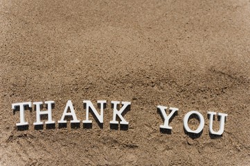 thank you word drawn on the beach sand
