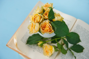 composition of an open book and yellow roses