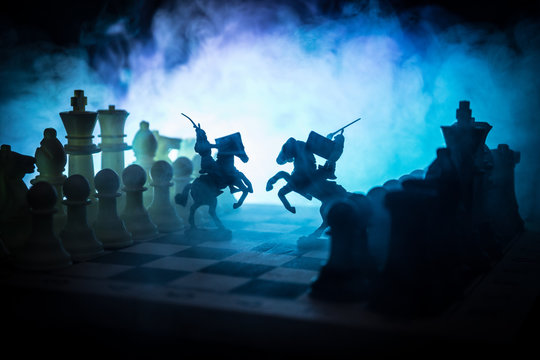 Medieval battle scene with cavalry and infantry on chessboard. Chess board game concept of business ideas and competition and strategy ideas Chess figures on a dark background
