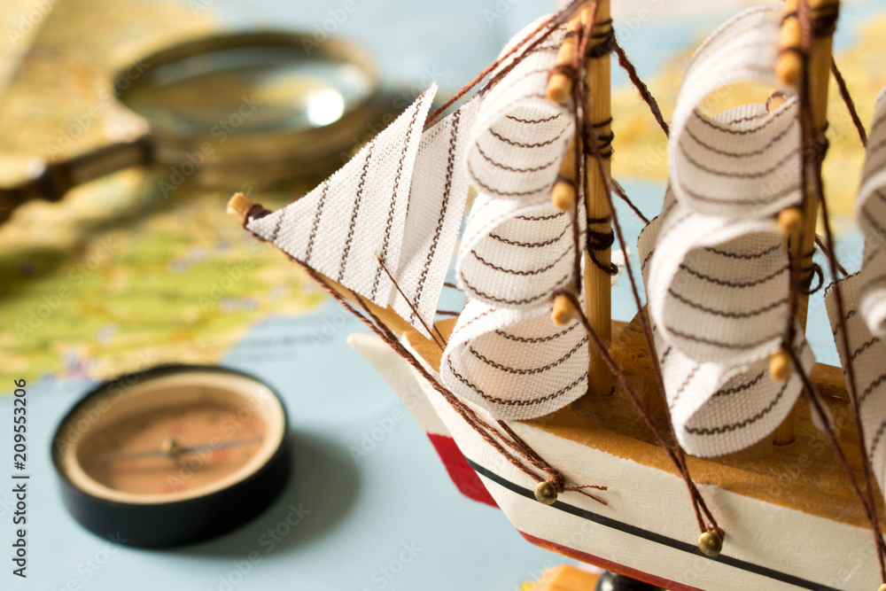 Canvas Prints model sailboat, compass and magnifying glass on map background. travel concept