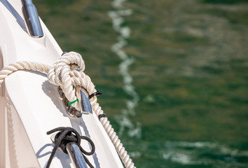 dock cleat on the side of a boat in a small marina, an element of yachting equipment