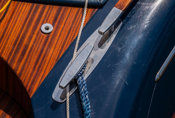 dock cleat on the side of a boat in a small marina, an element of yachting equipment