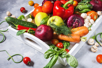 Raw organic vegetables with fresh ingredients for healthily cooking in white tray on concrete background