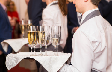 the waiter offers guests champagne