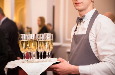 the waiter offers guests champagne