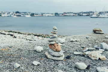 Stones pyramid on pebble beach symbolizing stability, zen, harmony, balance. Shallow depth of field.