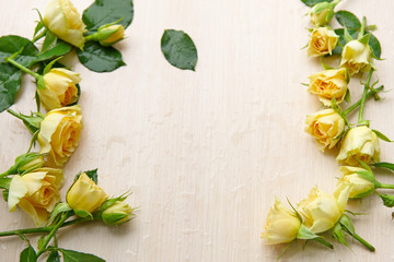 Fototapeta premium several yellow roses on a wooden background