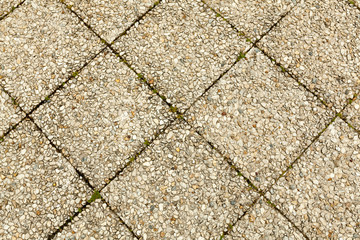 Pebble stone floor tile seamless background. Cement mixed gravel pebble stone floor texture. Wet round pebble stone rock floor in dramatic lighting.