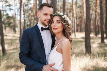 Obraz premium Bride and groom at wedding Day walking Outdoors on summer nature. Bridal couple, Happy Newlywed woman and man embracing in green park. Loving wedding couple outdoor. Bride and groom