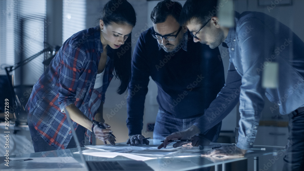 Poster late at night team of design engineers collectively work on the project. they inspect drafts, docume