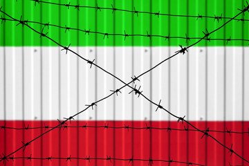National flag of Iran on fence. Barbed wire in the foreground symbolizes entry ban or prohibition...