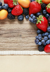 Delicious fruits: strawberry, grape, kumquat, blueberry and blackberry, on wooden background