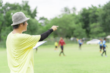 Football or socker coach observing kid football match.Healthy sport concept.