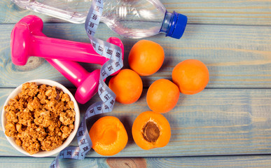 Healthy breakfast with granola, fresh vegetables and fruits on blue table.