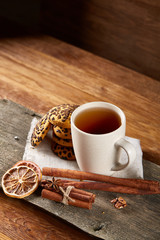 Cup of tea and chocolate chip cookies on white homespun napkin in country style, selective focus.