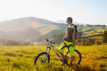 Fototapeta premium A cyclist on a mountain bike rises uphill. And looks at the scenic landscape.