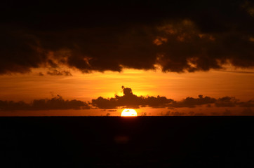 Sunset time at a beautiful island with orange gradient colour of sky and people playing around the...