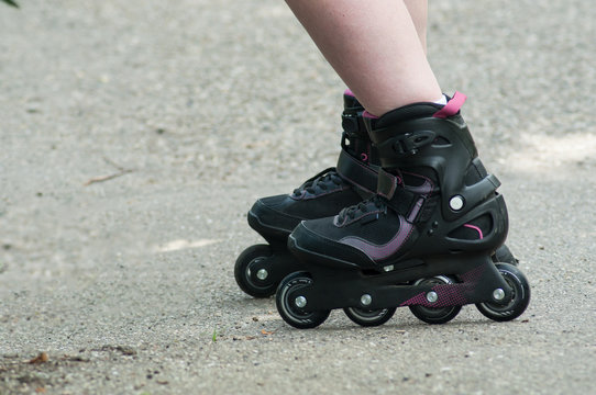 closeup of feet of woman with roller blade on the road